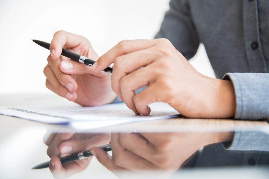businessman sitting at table with pen in hands